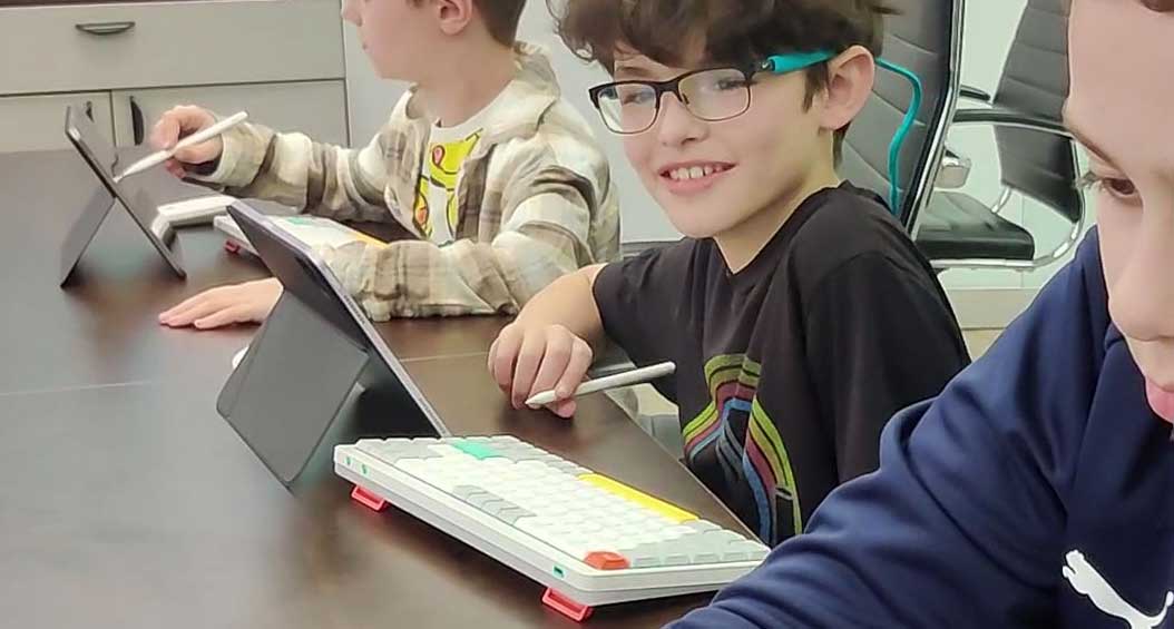 Students creating games on tablets in a Game Design Academy class